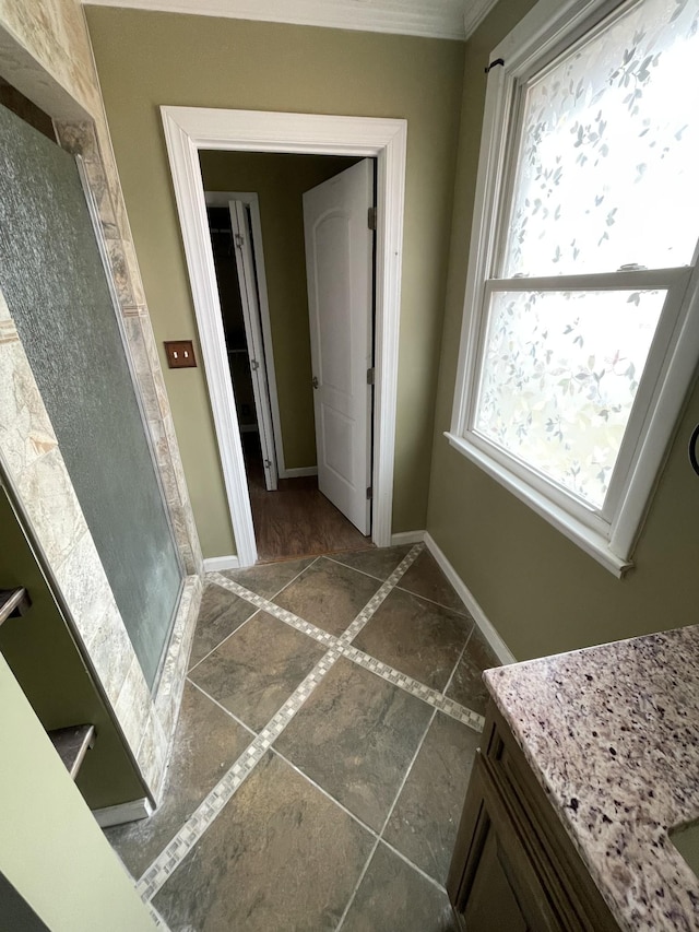 hallway with crown molding and baseboards