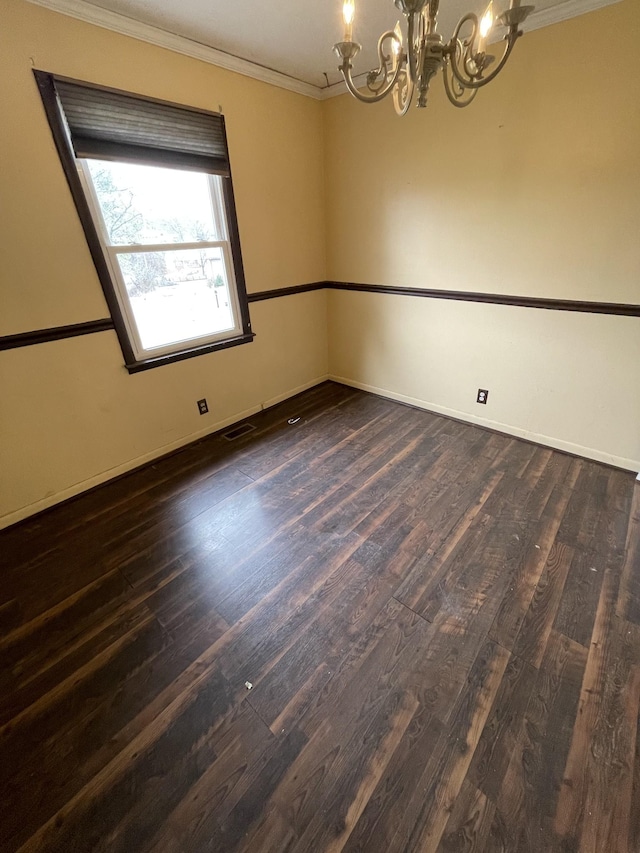 spare room with visible vents, wood finished floors, a chandelier, and ornamental molding