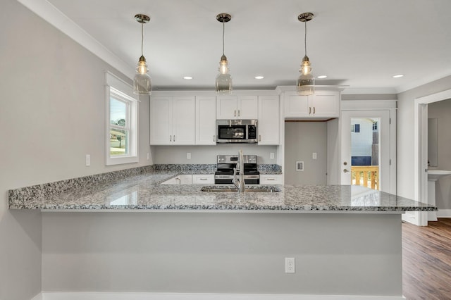 kitchen featuring a peninsula, white cabinets, light stone counters, and appliances with stainless steel finishes