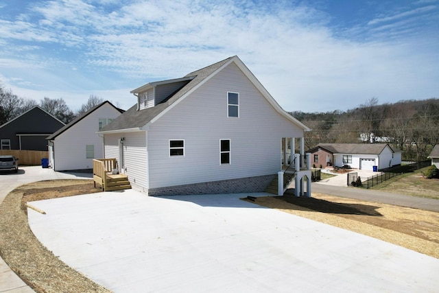 view of side of property with concrete driveway and fence