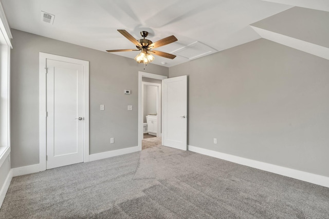 unfurnished bedroom featuring a ceiling fan, baseboards, visible vents, attic access, and carpet flooring