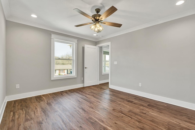 empty room with crown molding, baseboards, and wood finished floors