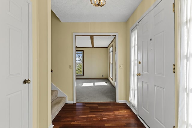 entryway featuring baseboards, a textured ceiling, and dark wood-style floors