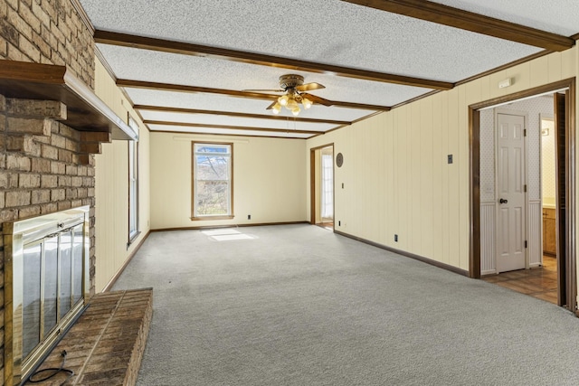 unfurnished living room featuring beamed ceiling, a textured ceiling, carpet, and a ceiling fan