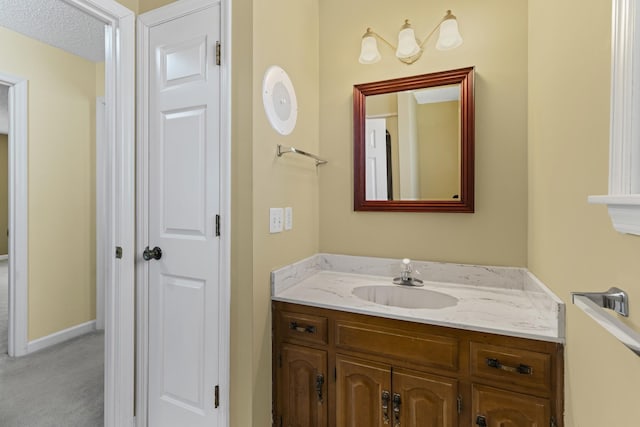 bathroom featuring vanity, baseboards, and a textured ceiling