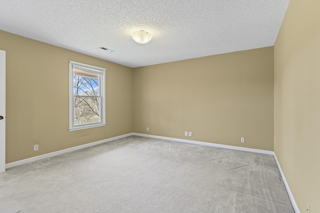 unfurnished room featuring carpet flooring, baseboards, visible vents, and a textured ceiling
