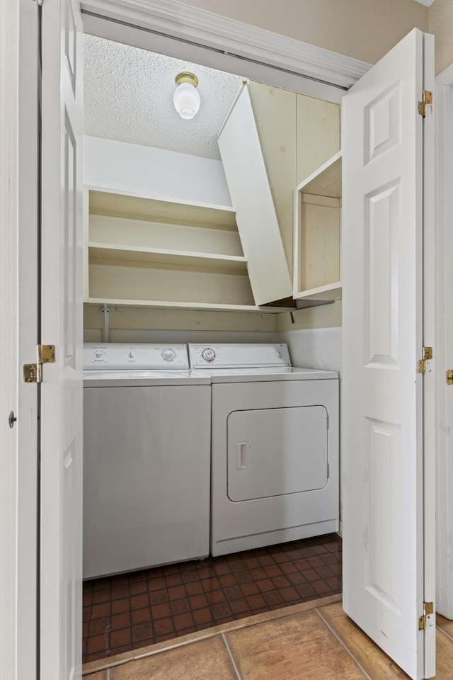 washroom with tile patterned floors, separate washer and dryer, laundry area, and a textured ceiling