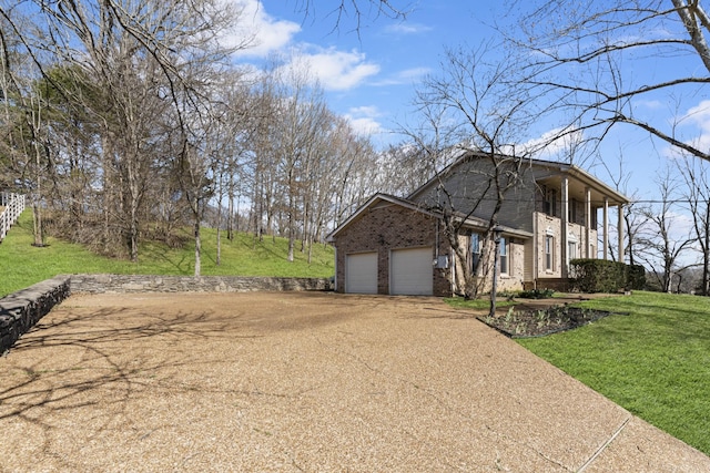 view of side of home featuring brick siding, a lawn, an attached garage, and dirt driveway