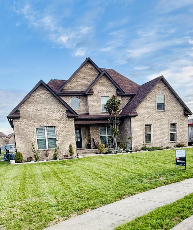 craftsman inspired home with a front lawn, brick siding, and a shingled roof