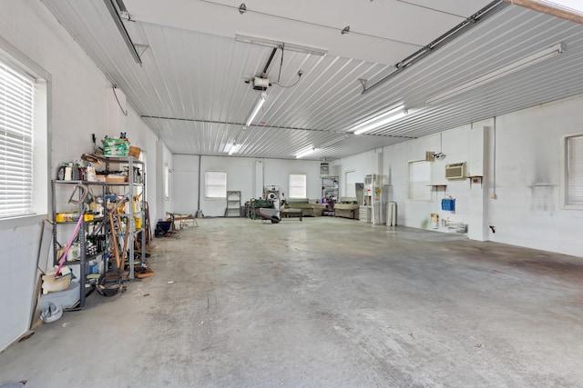 garage with a garage door opener, metal wall, and a wall unit AC