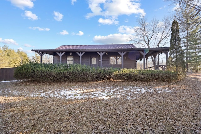 view of front of house with metal roof, a porch, and fence