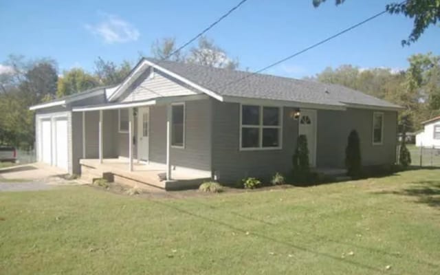 exterior space featuring a garage, a yard, a porch, and driveway