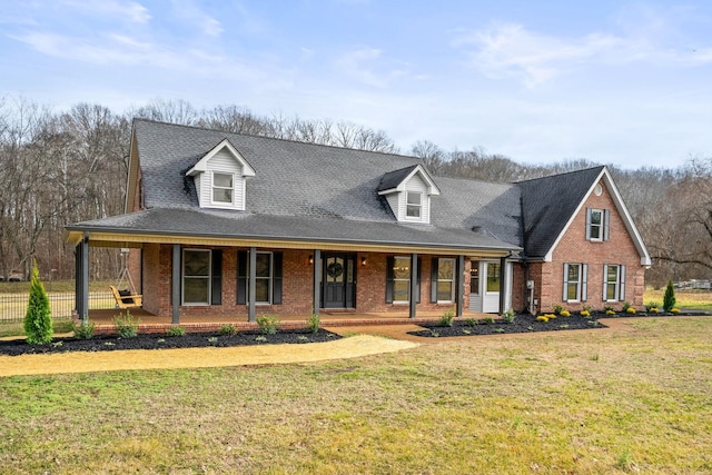 view of front of house with brick siding, a porch, and a front lawn