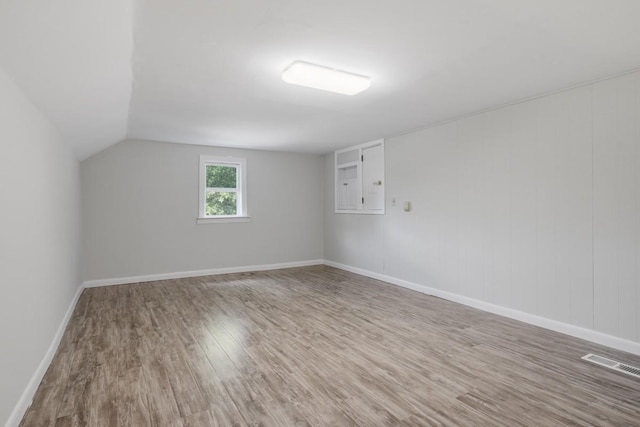 bonus room featuring visible vents, lofted ceiling, baseboards, and wood finished floors