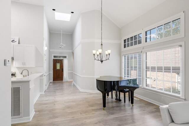 foyer with an inviting chandelier, baseboards, visible vents, and light wood finished floors