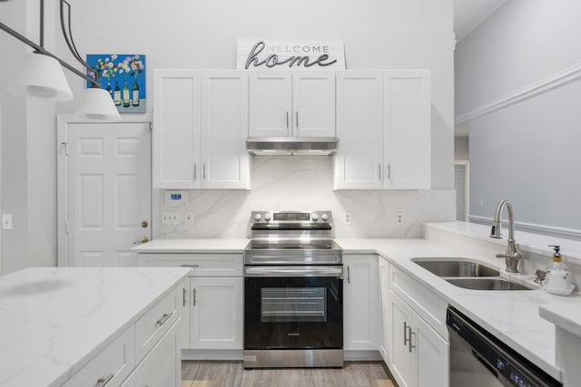 kitchen with a sink, decorative backsplash, stainless steel appliances, under cabinet range hood, and white cabinetry