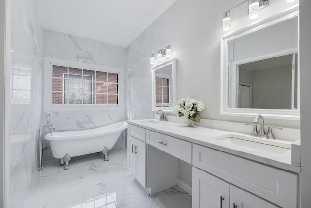 full bath with double vanity, a soaking tub, marble finish floor, and a sink