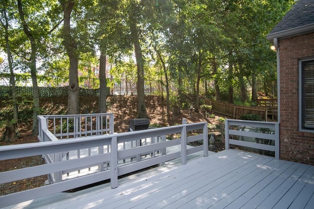 wooden terrace featuring a grill and fence