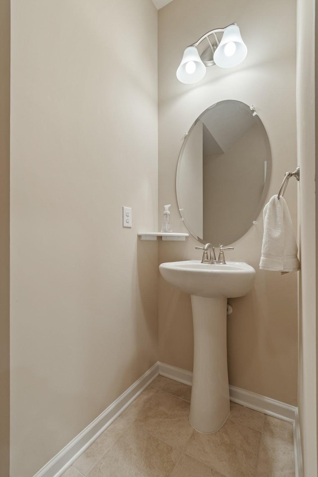 bathroom with a sink, baseboards, and tile patterned flooring