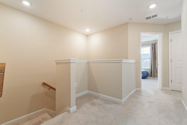 corridor featuring an upstairs landing, visible vents, and baseboards