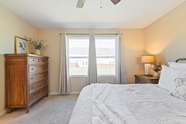 bedroom featuring baseboards, light colored carpet, and ceiling fan