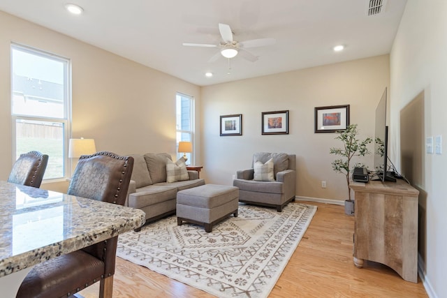 living room featuring visible vents, baseboards, recessed lighting, ceiling fan, and light wood-style floors