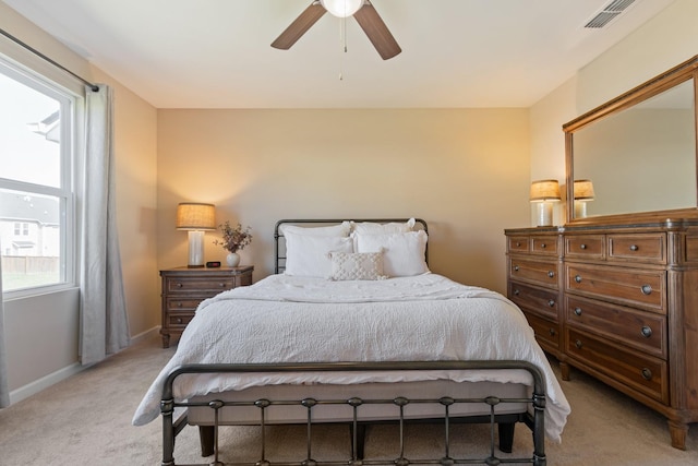 bedroom with light carpet, visible vents, a ceiling fan, and baseboards