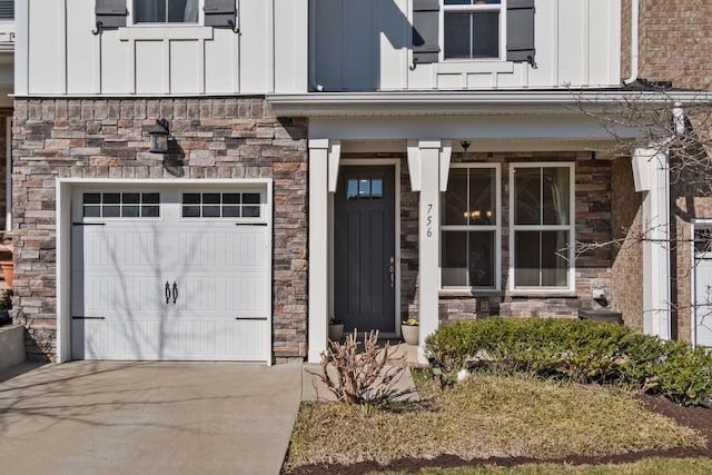 view of exterior entry featuring stone siding, board and batten siding, and concrete driveway