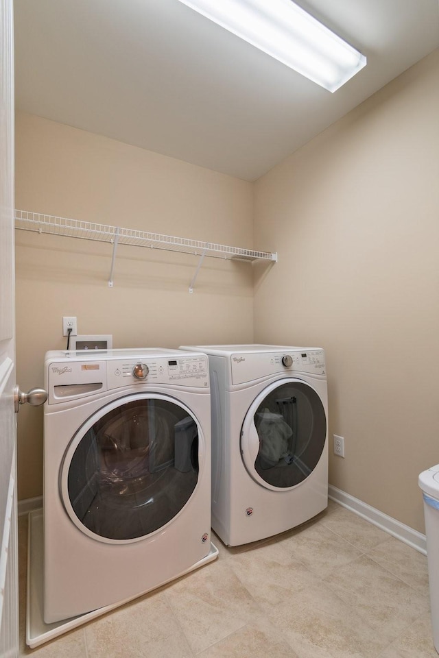 laundry area featuring laundry area, washing machine and dryer, and baseboards