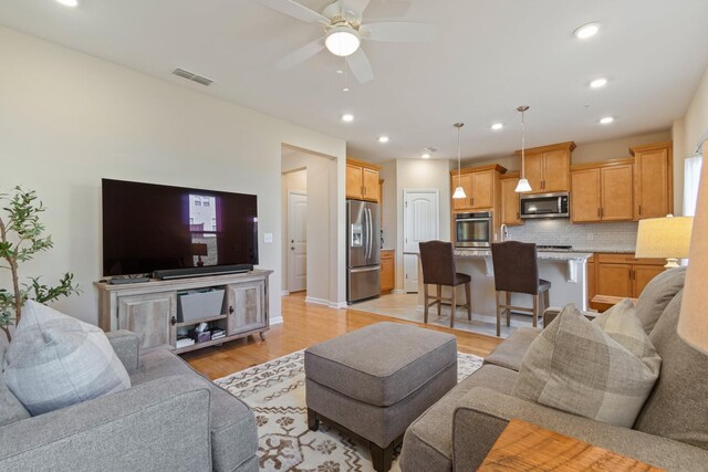 living room with recessed lighting, visible vents, light wood-style floors, and ceiling fan