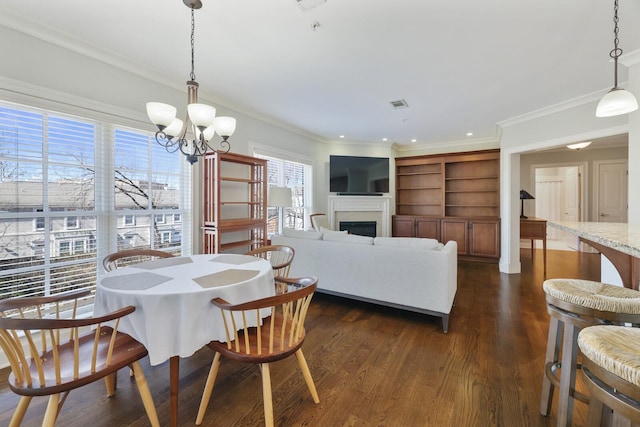 dining room featuring dark wood-type flooring, a fireplace, visible vents, and ornamental molding