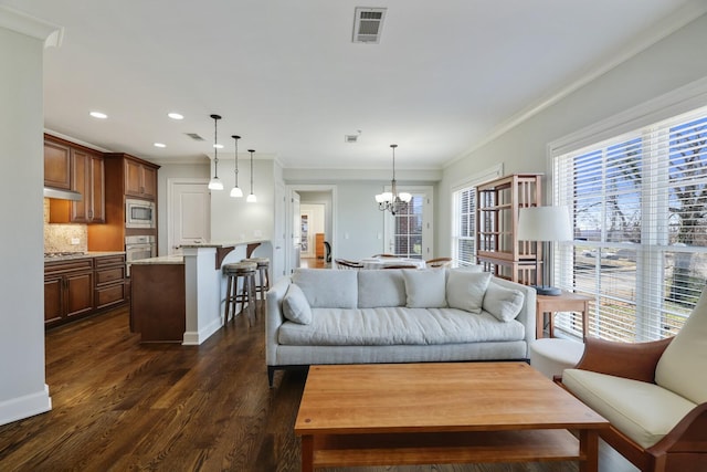 living room featuring crown molding, dark wood-style floors, visible vents, and a chandelier