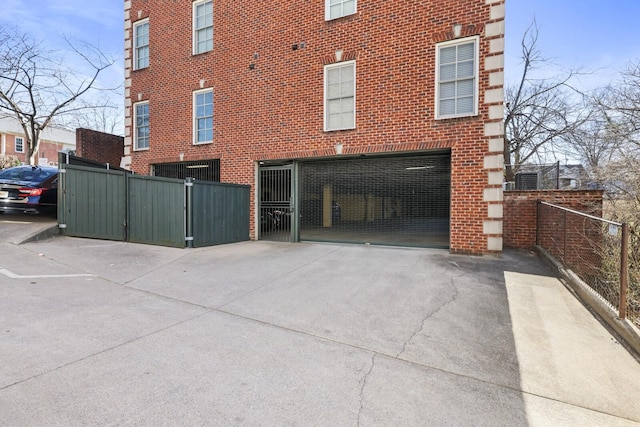 view of property exterior featuring brick siding and fence