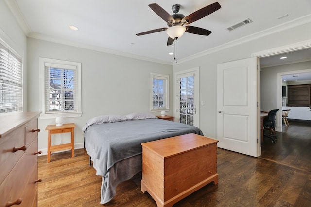 bedroom with wood finished floors, visible vents, and ornamental molding