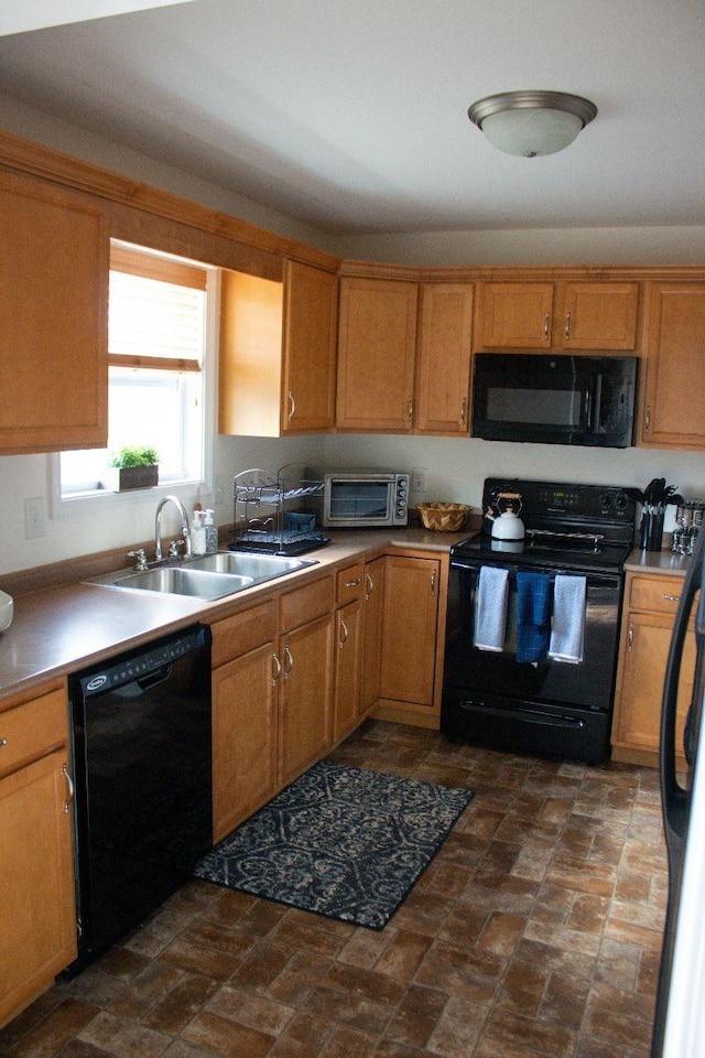 kitchen featuring a sink, black appliances, brown cabinetry, and a toaster