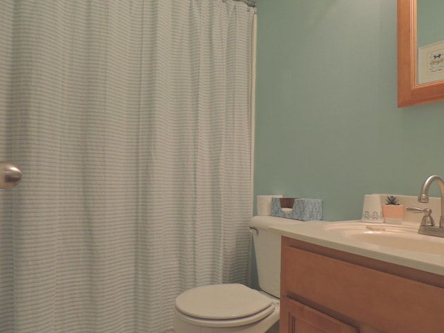 full bath with curtained shower, toilet, and vanity