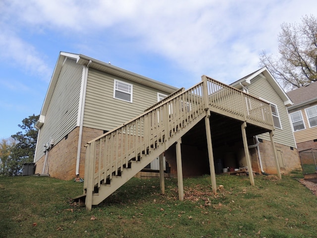 back of property featuring stairway, a lawn, and a wooden deck