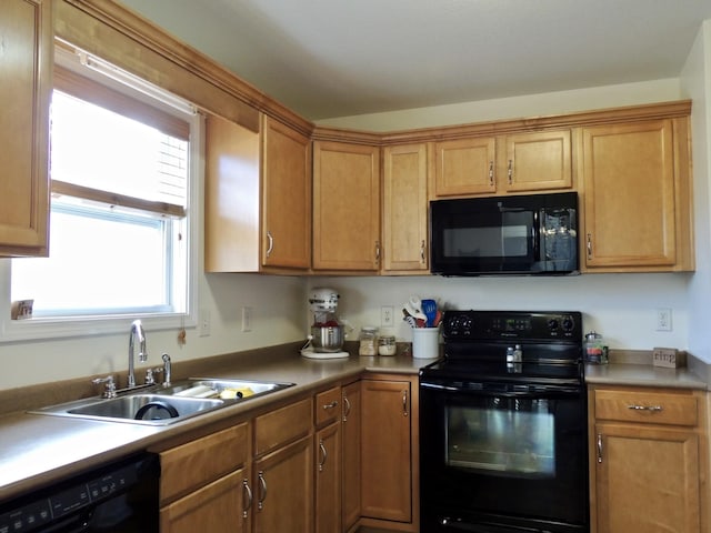 kitchen featuring black appliances, brown cabinetry, light countertops, and a sink