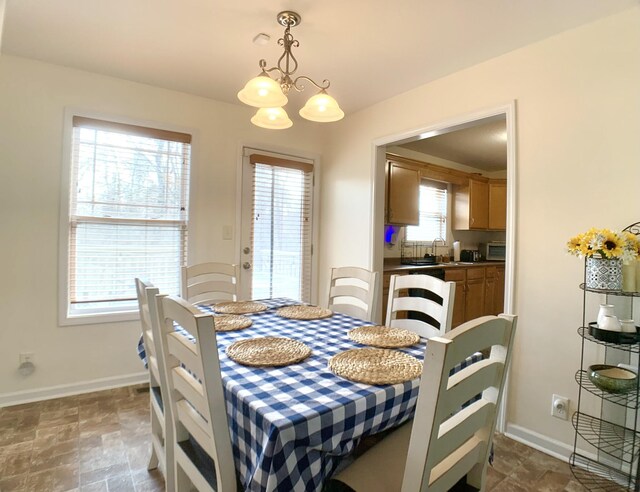 1016 Sunset Dr, Clarksville, TN 37040 - dining room featuring an inviting chandelier, stone finish flooring, and baseboards