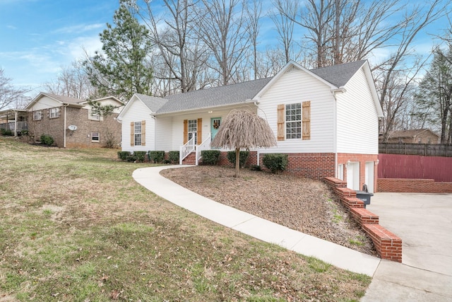 ranch-style home featuring fence, driveway, roof with shingles, a front lawn, and a garage