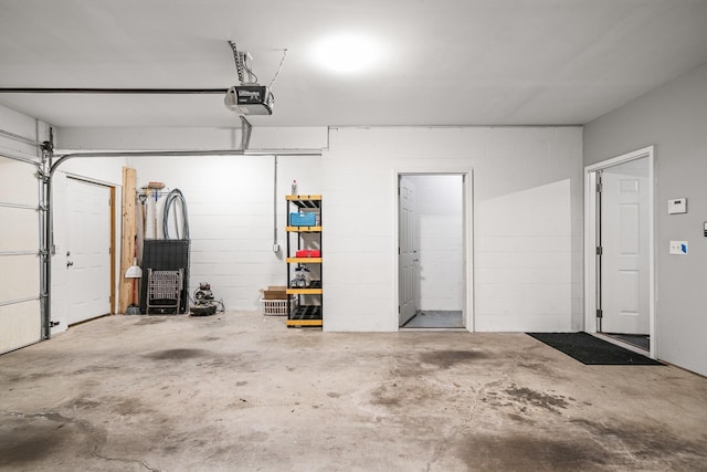 garage with concrete block wall and a garage door opener