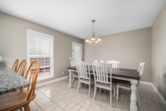 dining area with light tile patterned floors, baseboards, and a chandelier