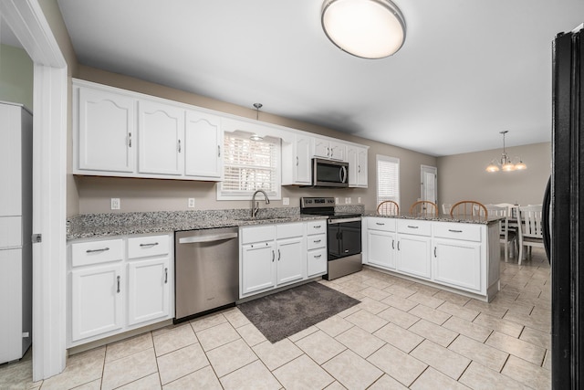 kitchen featuring light stone counters, white cabinetry, a peninsula, and stainless steel appliances