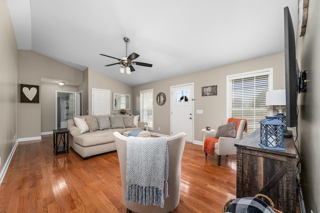 living room with plenty of natural light, light wood-style floors, and vaulted ceiling