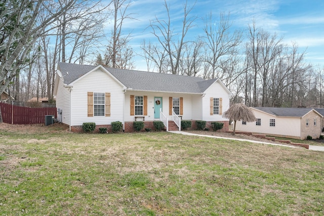 ranch-style house featuring central AC unit, roof with shingles, a front lawn, and fence