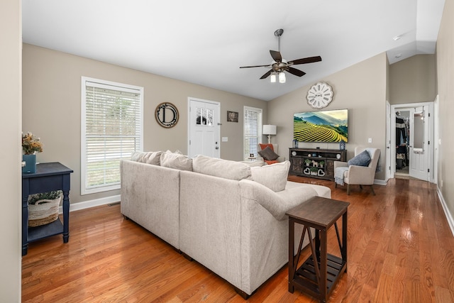 living room with vaulted ceiling, baseboards, a ceiling fan, and wood finished floors