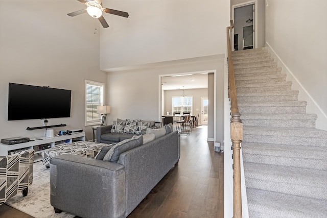 living area featuring stairs, a healthy amount of sunlight, and dark wood-style flooring