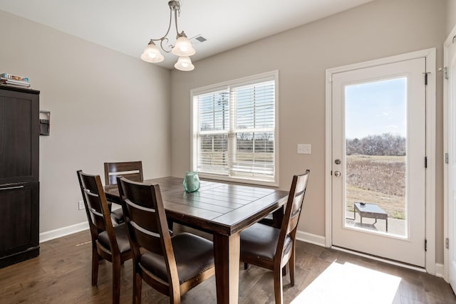 dining area with visible vents, baseboards, dark wood-type flooring, and a chandelier