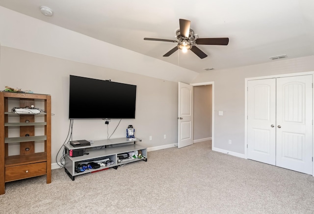 carpeted living area with visible vents, ceiling fan, baseboards, and lofted ceiling