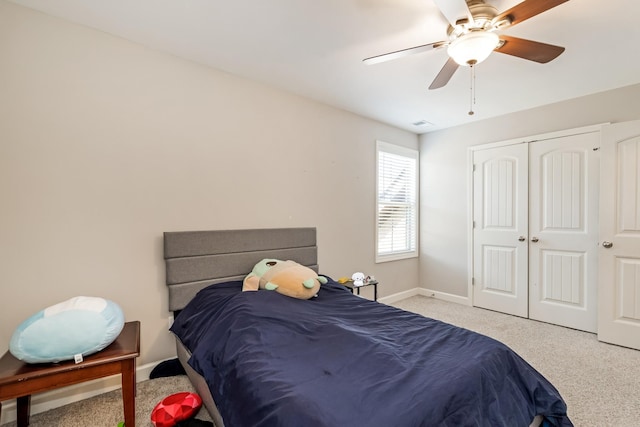 carpeted bedroom featuring a closet, ceiling fan, and baseboards